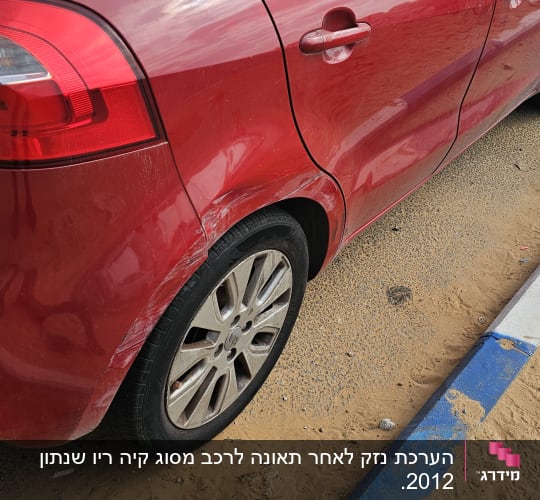מכונית אדומה עם שריטות על הפגוש האחורי
